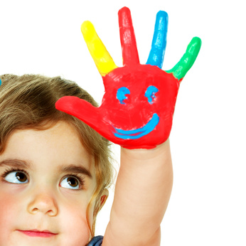 Little girl shows her coloured hand with a smiling face
